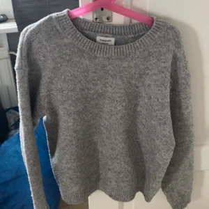 Grå stickad tröja från Kappahl - Mysig grå stickad tröja från Kappahl med rund halsringning och ribbade muddar. Perfekt för kyliga dagar och enkel att matcha med jeans eller kjol. Långärmad och i klassisk modell som funkar året runt.