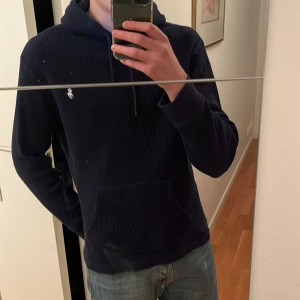 Mörkblå hoodie från Polo Ralph Lauren - Säljer en otroligt cool o skön mörkblå hoodie från Polo Ralph Lauren 🔥Den har ribbad struktur och är tunnare än en vanlig hoodie, vilket gör att den känns lite mer lyxig. Storlek M men passar även S väldigt bra. Inga defekter. Hör av er vid frågor 🙌