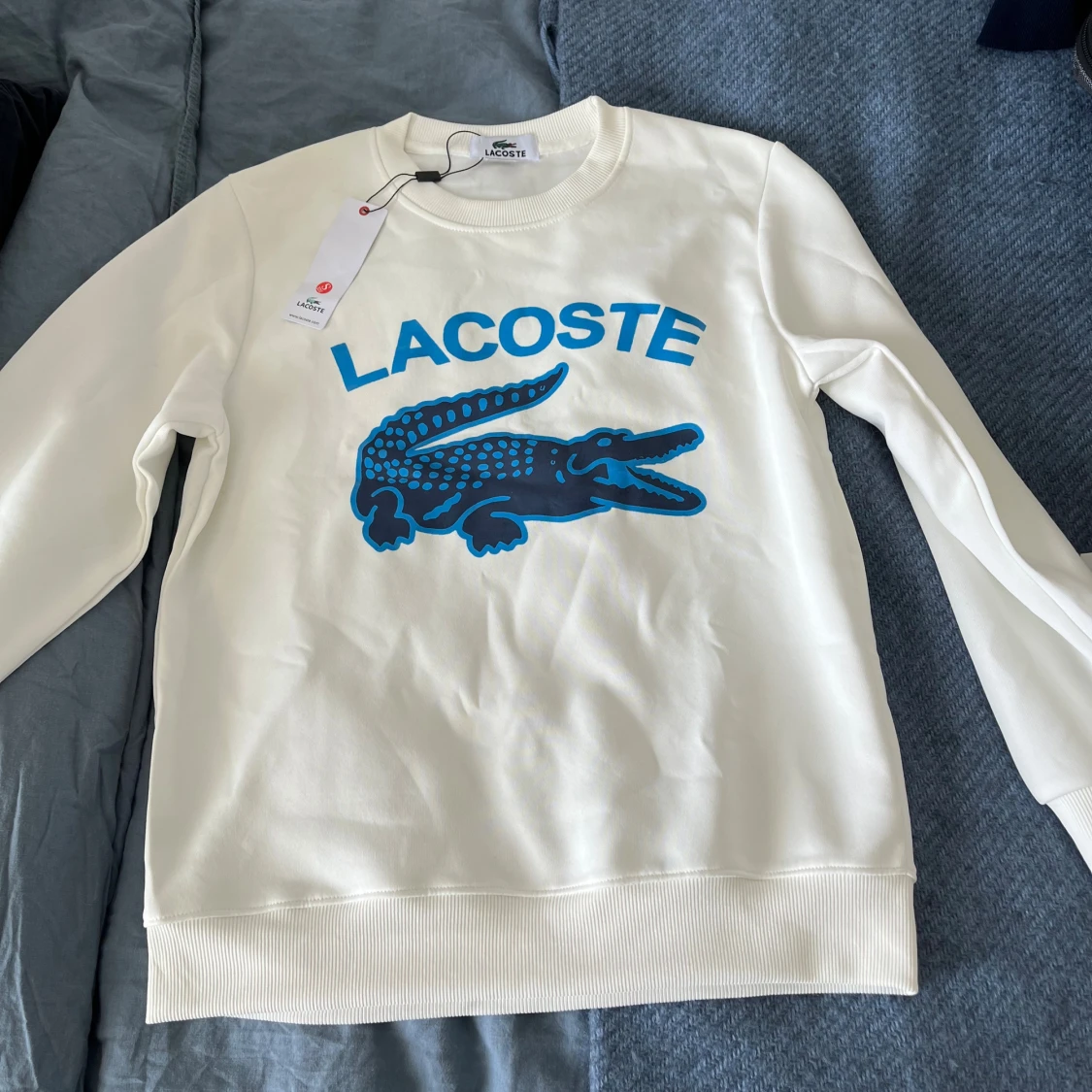 Vit sweatshirt från Lacoste med blå logga