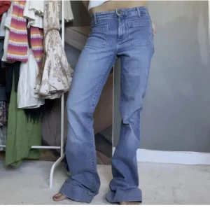 Blå bootcut jeans från wrangler - Snygga ljusblå jeans med bootcut-modell. Jeansen har framfickor med markerade sömmar och klassisk dragkedja🌸