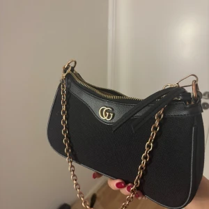 Handväska - En fin svart väska med kedja, kedjan har tappat sin färg lite