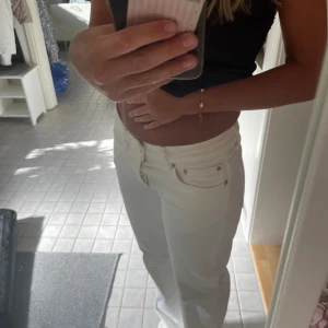Vita raka jeans med hög midja - Säljer ett par vita jeans med raka ben och mid midja. Snygg passform och perfekt till en fräsch look. Materialet känns som bomull med lite stretch.