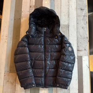Navy blue Moncler Maya  - Säljer en navy blue Moncler Maya Jackan har dragkedja framtill, sidofickor och klassisk Moncler-logga på ärmen. Perfekt för kalla dagar och riktigt snygg.
