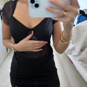 Svart meshtshirt med spetsdetaljer - Supersnygg svart tshirt från H&M i mesh med transparenta partier och spetsdetaljer vid bysten. 