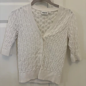 Vit kofta från Kappahl med spetsmönster - Superfin vit kofta från Kappahl i storlek S. Koftan har ett vackert spetsmönster, v-ringning och knappar framtill. Priset kan diskuteras