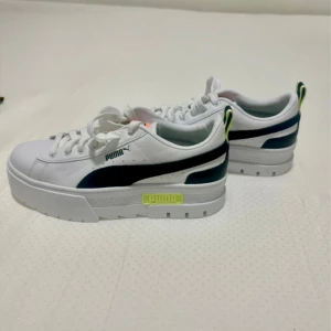 Helt nya sneakers från Puma med platåsula - Nya och använda Puma Mayze sneakers. Snygga vita Puma sneakers med svart logga på sidan och cool platåsula. Skorna har snörning, detaljer i neongult. Perfekta för dig som vill ha en sportig och trendig look med extra höjd. I storlek 38, finns ej kartong!