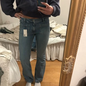 Bootcut ljusblå jeans med fickor - Snygga ljusblå jeans från Lager 157 med bootcut passform och stora, fyrkantiga fickor fram. Jeansen har hög midja och klassisk femficksdesign baktill. Materialet är mjukt denim och färgen är fräsch och ljus, perfekt för en chill och trendig look.