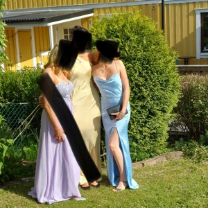 Ljusblå balklänning från NLY Eve - Säljer en elegant ljusblå balklänning från NLY Eve i storlek 34. smala axelband, slits på sidan och en snygg draperad urringning. Materialet är mjukt och har en satinliknande finish som ger en lyxig känsla. Perfekt för student eller bal!