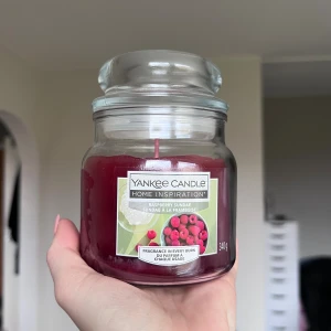 Yankee Candle - Raspberry Sundae  - Stor doftljus på 340g från Yankee Candle, doft Raspberry Sundae. Glasburken och veken är i mycket gott skick, ljuset är oanvänt. Ger en god, bärliknande och fräsch doft. Perfekt för att skapa en mysig atmosfär hemma. Köper du innan kl 16:00 kan jag skicka samma dag! 