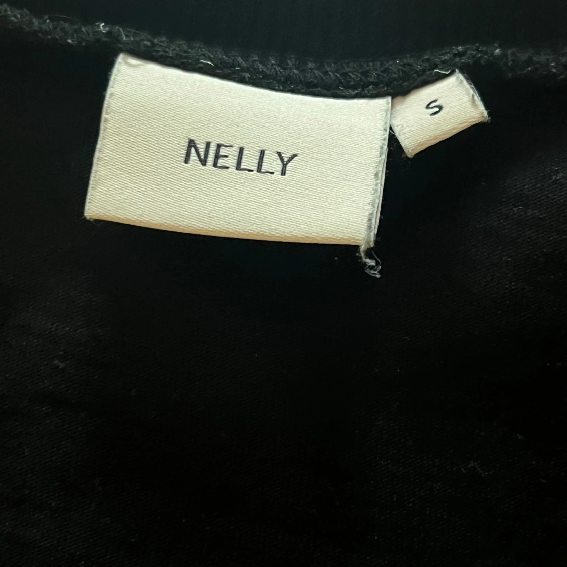 Svart tröja från Nelly med knyttning i ryggen. Storlek S - 4