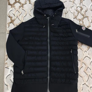Svart Moncler cardigan med huva - Tja! Säljer en Moncler cardigan i fint skick, vilket har använts fåtal gånger. Den har inga defekter och om du vill se mer bilder det är bara att fråga! Pris kan diskuteras vid snabb affär.