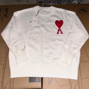 Vit stickad tröja  - Jätte fin tröja som är vit och har ett rött märke vid sidan där framme. Den är jätte skön och ha på sig. Pris kan diskuteras