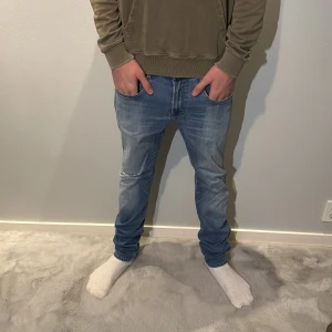 Replay ljusblå jeans med tapered fit - Snygga ljusblå jeans från Replay med klassisk femficksdesign och diskret Replay-logga vid fickan. Jeansen har tapered passform, normal midja och är tillverkade i mjukt jeanstyg. Perfekt för dig som gillar en avslappnad men stilren look. Modellen på bilden är 190cm lång och väger 75kg