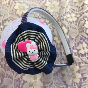 Hello Kitty diadem med rosett  - Tre gulliga diadem med rosett  med rosa klänning och hjärta. Ett diadem har marinblå och vitrandig rosett, de andra har ljusrosa rosett. Diademen har olika färger på bandet: mörkblått med prickar, beige med prickar och grönt. Perfekt för att ge din look en söt touch.  35kr/st , helt ny 