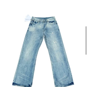 Wide jeans från Acne Studios ljusblå - Ljusblå jeans från Acne Studios med breda ben och lätt slitna detaljer framtill. Klassisk femficksmodell i bomull med polyester i fickfoder. Snyggt avslappnad passform och cool tvätt, perfekt för en trendig look.