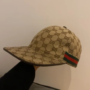 Beige Gucci Keps ÄKTA - Säljer nu min GG keps utan defekter men tyvärr ej paket då jag fått den via ett byte hör av er vid frågor eller mer bilder , Obs pris går självklart att diskutera 