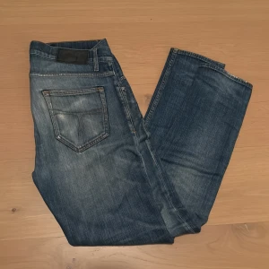 Blåa tiger of sweden jeans  - Blåa jeans från tiger of sweden med modellen pistolero. Klassisk femficksdesign och lätt slitna detaljer framtill. Jeansen har normal midja och raka ben, tillverkade i mjukt bomullsmaterial för skön passform.