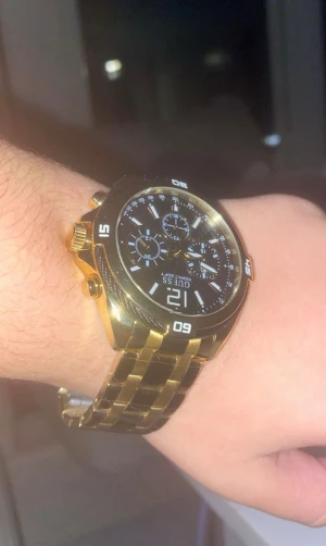 Guess guldig klocka med svart urtavla - Säljer en snygg klocka från Guess med guldig länk och svart urtavla. Klockan har flera små urtavlor, tydliga vita markeringar och robust design. Perfekt accessoar för dig som vill sticka ut med stilren och modern look.