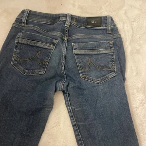 Blå jeans från LTB Valerie - Snygga blå jeans från LTB Valerie med klassisk femficksdesign och kontrastsömmar. Jeansen har låg midja och raka ben, tillverkade i slitstarkt denim med en mörk tvätt. Perfekt för dig som gillar en enkel och tidlös look. Storlek w26/30. Lite korta på mig som är 170.
