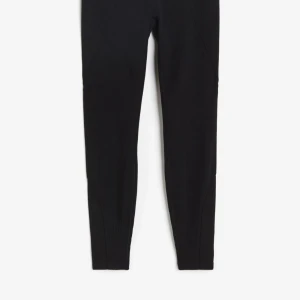 Svarta träningstights från H&M Move - Snygga och bekväma svarta träningstights från H&M Move. Tillverkade av 76% återvunnen polyester med DryMove™-teknologi för att hålla dig torr under träningen. De är högmidjade och fullängd, perfekta för alla träningspass.