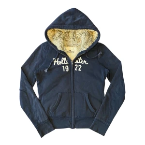 Hollister fodrad zip up hoodie - Hollister zip up hoodie i storlek M. Mått: axelbredd - 37 cm, längd - 55 cm. Skriv för fler bilder och frågor!