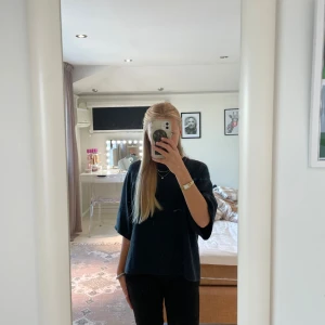 Mörkblå stickad tröja med vida ärmar - Mysig mörkblå stickad tröja med lös passform och trekvartsärmar. Tröjan har en enkel och stilren design, perfekt att slänga på sig när man vill vara både bekväm och snygg. Passar till allt och är superenkel att styla.