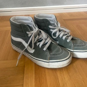 Gröna Vans Sk8-Hi sneakers - Snygga Vans Sk8-Hi sneakers i grå mocka med vita detaljer och klassisk vit sula. Högt skaft och vit sidestripe☺️