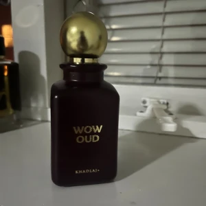 Khadlaj Wow Oud Eau de Parfum - Wow Oud från Khadlaj är en Eau de Parfum i en mörkbrun, fyrkantig flaska med en lyxig rund guldfärgad kork. Flaskan har guldtext och levereras i en matchande brun och guldig förpackning. Doften är inspirerad av oud och har en exklusiv vibe. Ungefär 85ml kvar om inte mer. Knappt använd. 