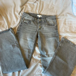 Grå jeans från Gina Tricot, stl 152 - Snygga grå jeans från Gina Tricot i storlek 152. Klassisk femficksmodell med raka ben och silverfärgade knappar framtill. Jeansen har en cool, lite tvättad look och är tillverkade i mjukt denimtyg som sitter skönt hela dagen.