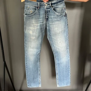 Ljusblåa jeans från Dondup (31) - Säljer ett par ljusblå jeans från Dondup med slitna detaljer och råa kanter. Jeansen är i bra skick och reparerade mellan benen. Storlek 31