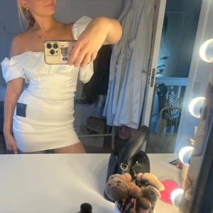 Vit offshoulder klänning/ studentklänning - Supersöt vit kortklänning från Lulus med offshoulder och volang upptill. Klänningen har en figurnära passform😊 passar perfekt som studentklänning!