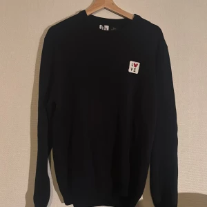 Blå tröja Zara x Disney Mickey Mouse - Svart långärmad tröja från Zara i samarbete med Disney Mickey Mouse. På bröstet sitter en liten patch med texten 'LOVE' och ett rött hjärta. Enkel och stilren design, perfekt för dig som gillar subtila Disney-detaljer.