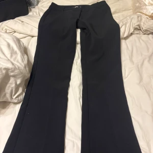 Svarta kostymbyxor med bootcut - Säljer ett par svarta kostymbyxor med bootcut och normal passform. knappast använda då jag har ett par andra. 