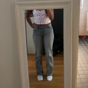 Grå raka jeans mid waist  - Säljer ett par grå jeans som är mid waist och raka ben. Jeansen har klassisk femficksdesign och stängs med dragkedja och knapp. Perfekta för en chill och stilren look, passar till allt och är superenkla att styla.