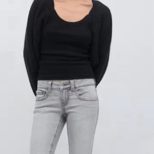 Grå bootcut jeans med fickdetaljer - Snygga ljusgrå jeans med bootcut-snitt och markerade sömmar. Byxorna har två bakfickor med lock och knapp, samt klassisk femficksdesign. Jeansen har normal passform och är tillverkade i mjukt denimtyg som sitter skönt hela dagen.