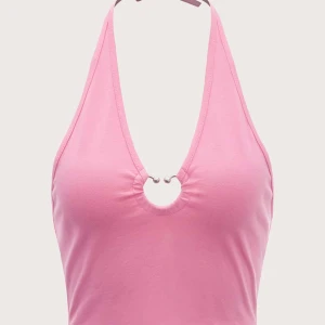 Rosa halterneck linnetopp med ringdetalj - Säljer en snygg rosa halterneck linnetopp med djup v-ringning och en silverfärgad ringdetalj framtill. Toppen är croppad och har knyt i nacken. Perfekt för dig som gillar trendiga och feminina plagg med lite edge.