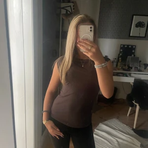 Brun ärmlös topp från lager 157 - Aldrig använt. Säljer en enkel och stilren brun topp från märket lagar 157 i storlek S. Toppen är ärmlös med rund halsringning.