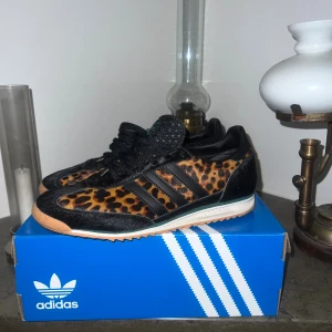 SL 72 OG adidas - Unika Adidas sneakers med svart och brun leopardmönstrad ovandel i pälsliknande material, svarta läderdetaljer och klassiska tre ränder. Skorna har svart snörning, gummisula i beige och gröna Adidas-loggor på hälen och innersulan. Perfekt för dig som vill sticka ut. Använd en gång där av priset, priset kan också diskuteras!