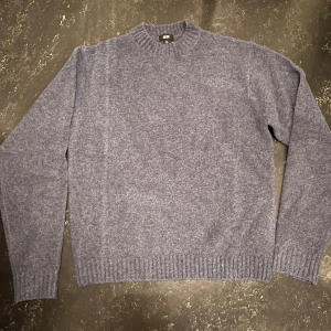 Grå stickad tröja från Uniqlo - Mysig grå stickad tröja från Uniqlo med rund halsringning och ribbade muddar. Perfekt för lager-på-lager och passar till både jeans och kjol. Enkel och stilren design som funkar året runt.