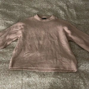 Beige stickad tröja från 157 XS - Mysig beige stickad tröja från 157 i storlek XS. Tröjan har rund halsringning, ribbade muddar och en loose passform. Perfekt för lager-på-lager och chill dagar. Enkel att matcha med jeans eller kjol.