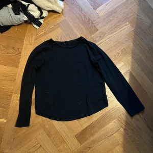 Svart långärmad tröja i bomull - Enkel svart långärmad tröja i mjuk bomull med rund halsringning. Perfekt basplagg att ha i garderoben och lätt att matcha med andra kläder. Snygg och stilren passform som funkar året runt.