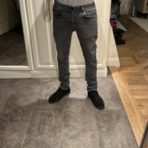 Grå jeans från dondup  - Säljer ett par grå jeans från Dondup Jeansen har smal passform med normal midja. Perfekta för dig som gillar en modern och stilren look. Materialet är mjukt och stretchigt för extra komfort. Waist 32 Lenght 32. Priset är inte hugget i sten och hör av er vid frågor!