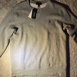 Grå sweatshirt från Polo Ralph Lauren - Snygg grå sweatshirt från Polo Ralph Lauren i storlek i storlek xl fast i barn model/ passar storlek s, tröjan är ny och helt oanvänd - priset kan diskuteras 