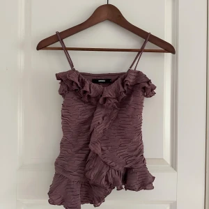 Lila volangtop från BikBok - Supersöt lila linnetopp från BikBok med tunna axelband och volangdetaljer. Använd endast 1 gång 🤍
