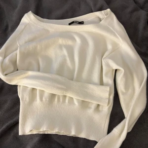 Vit stickad tröja från BikBok XS - Superfin vit stickad tröja från BikBok i storlek XS. Tröjan har bred ribbad mudd nertill och vid ärmslut, rund halsringning och lång ärm. Perfekt för lager-på-lager och enkel att matcha med jeans eller kjol.