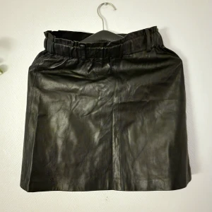 Svart skinnkjol från MNG Casual XS - Svart faux-läder kjol. Denna har följt med ut på en hel del dansgolv och är väldigt bekväm och stretchig. Nu är vi i flytt-mode, så den fick åka ut ur garderoben (tyvärr!)