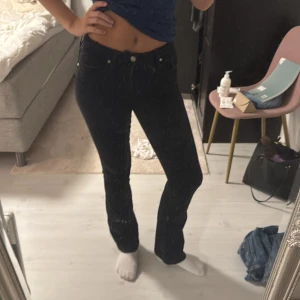 Svarta bootcut jeans - Säljer ett par svarta jeans med bootcut-modell och klassisk femficksdesign. Jeansen har normal passform och är tillverkade i ett mjukt denimtyg som sitter snyggt över höfterna och låren. Perfekta för dig som gillar en tidlös och clean look.