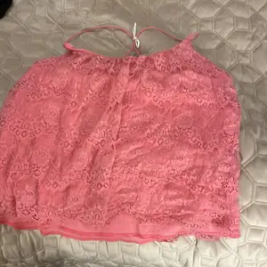 Ett linne med spetts som är rosa sitter jätte fint 