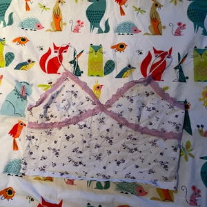 Vit croptop med blommor - Säljer en vit croptop med lila blommor och ljuslila spets