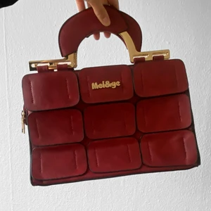 Röd handväska - Jättesöt röd handväska med ”guld” detaljer ❤️ väldigt rymlig. Bredd: 30 Djup: 10 Höjd: 20 (cm) i mycket gott skick